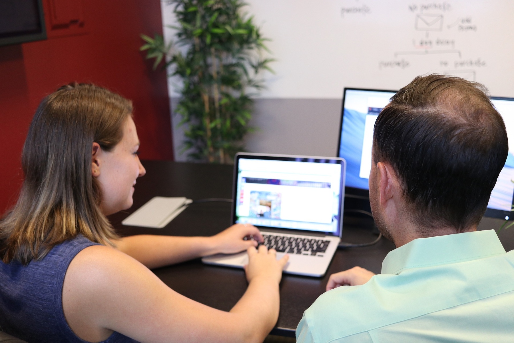 Woman showing his coworker the website she is working on