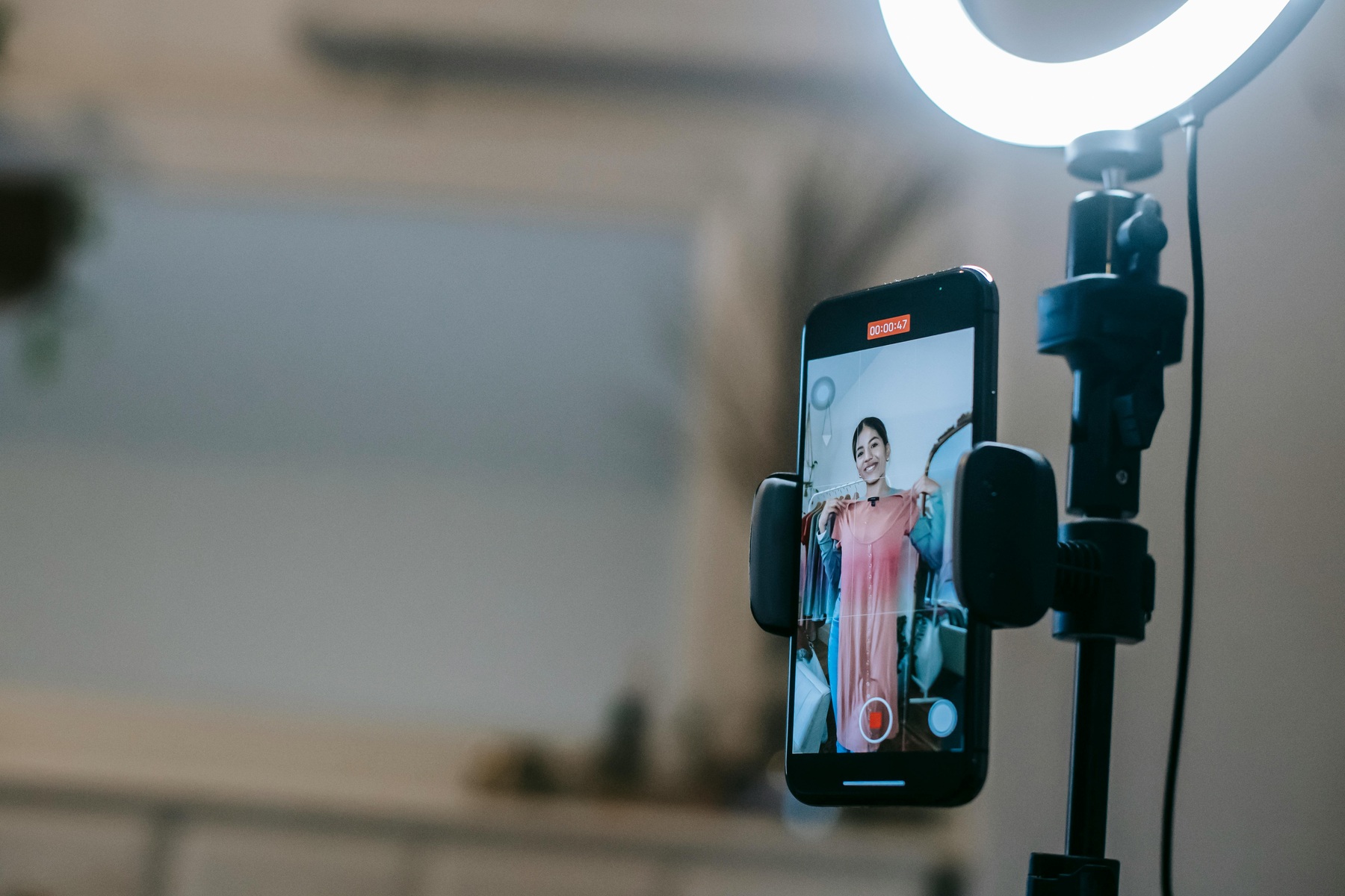 Faceless lady filming video on mobile while demonstrating dress